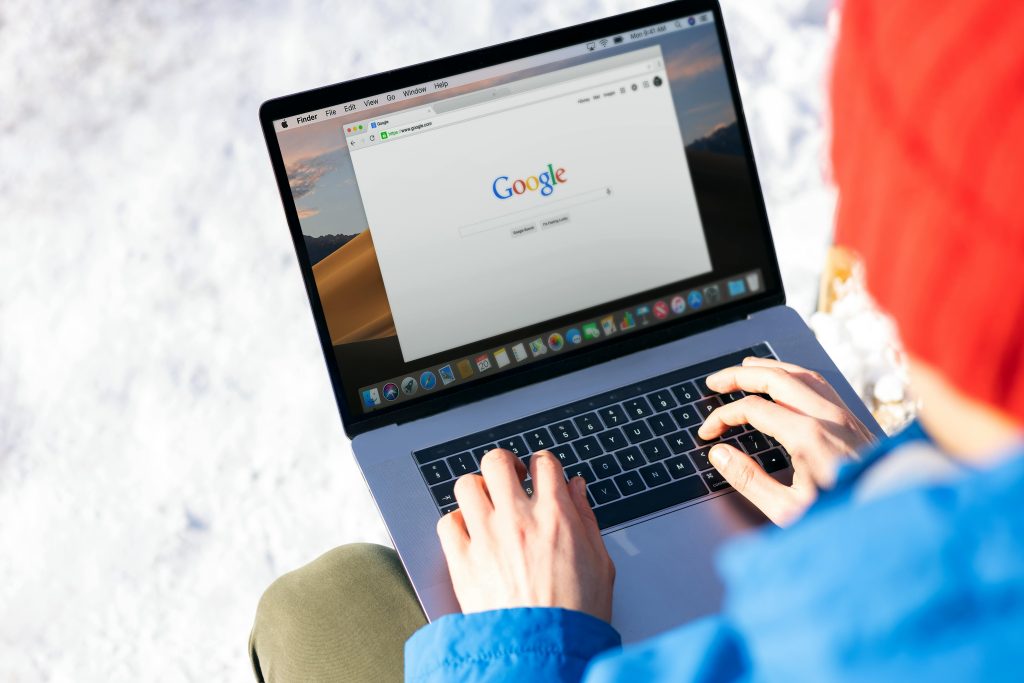 Suchmaschinenoptimierung: Eine Person sitzt am Laptop und sucht etwas auf Google.