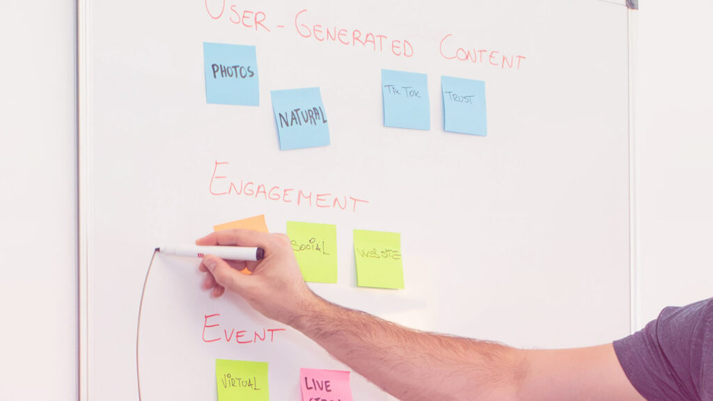 Marketing für kleine Unternehmen: Eine Person schreibt etwas auf ein Whiteboard.